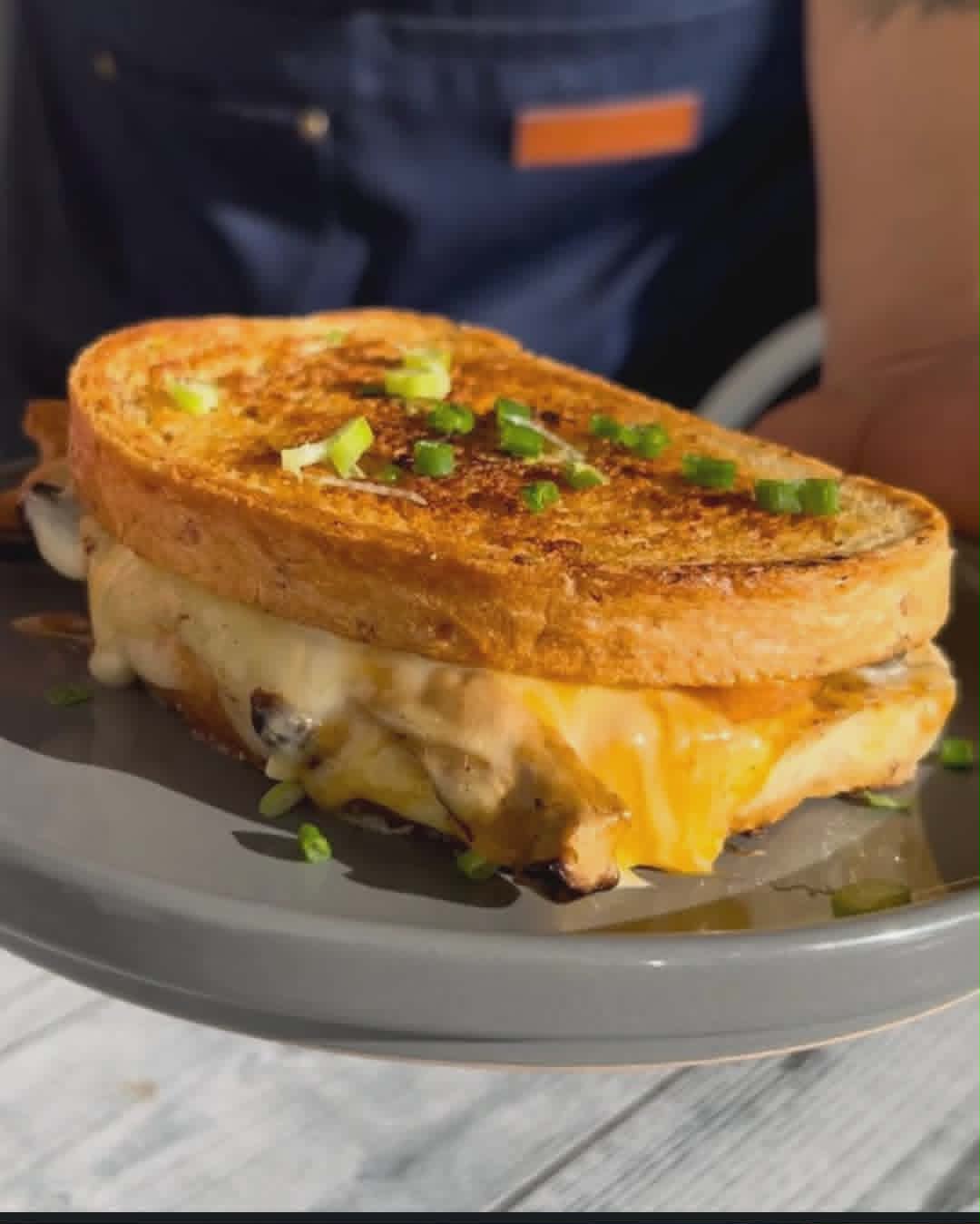 Wild mushroom grilled cheese, golden-toasted and oozing melted cheese, topped with scallion.